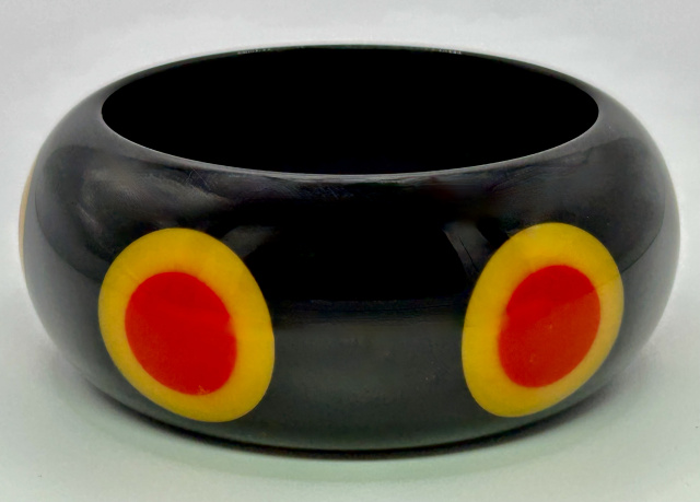 Judith Evans black resin bangle with red and yellow bullseye dots